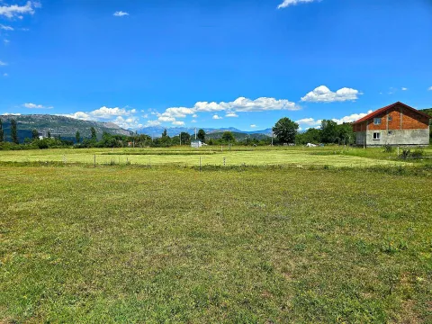 Prostrano travnato zemljište sa pogledom na planine i okolnu prirodu. - image 3