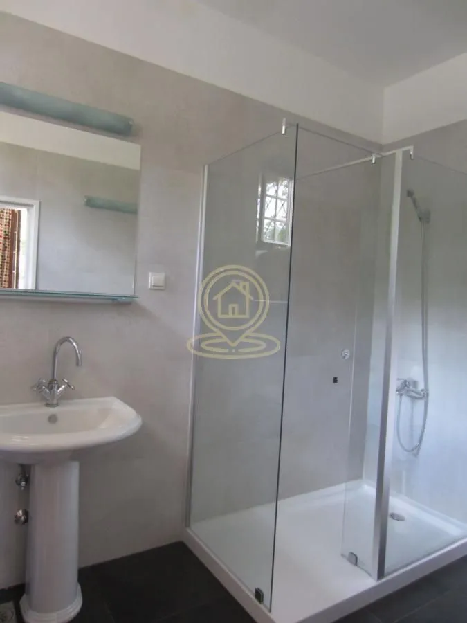 Bathroom with a sink and a glass shower cabin.