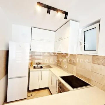 Small white kitchen with built-in cabinetry and a refrigerator. - image 6