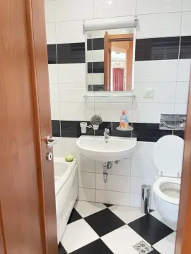 Pogled na moderno uređeno kupatilo sa kadom, umivaonikiem i toaletom. - image 9