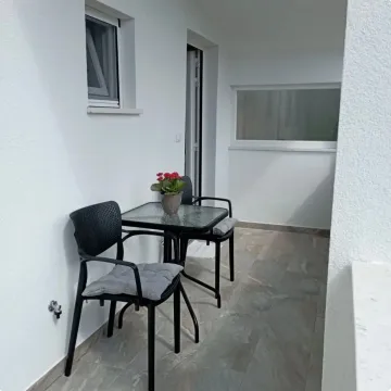 Natkrivena terasa sa crnim stolom i stolicama. - image 7