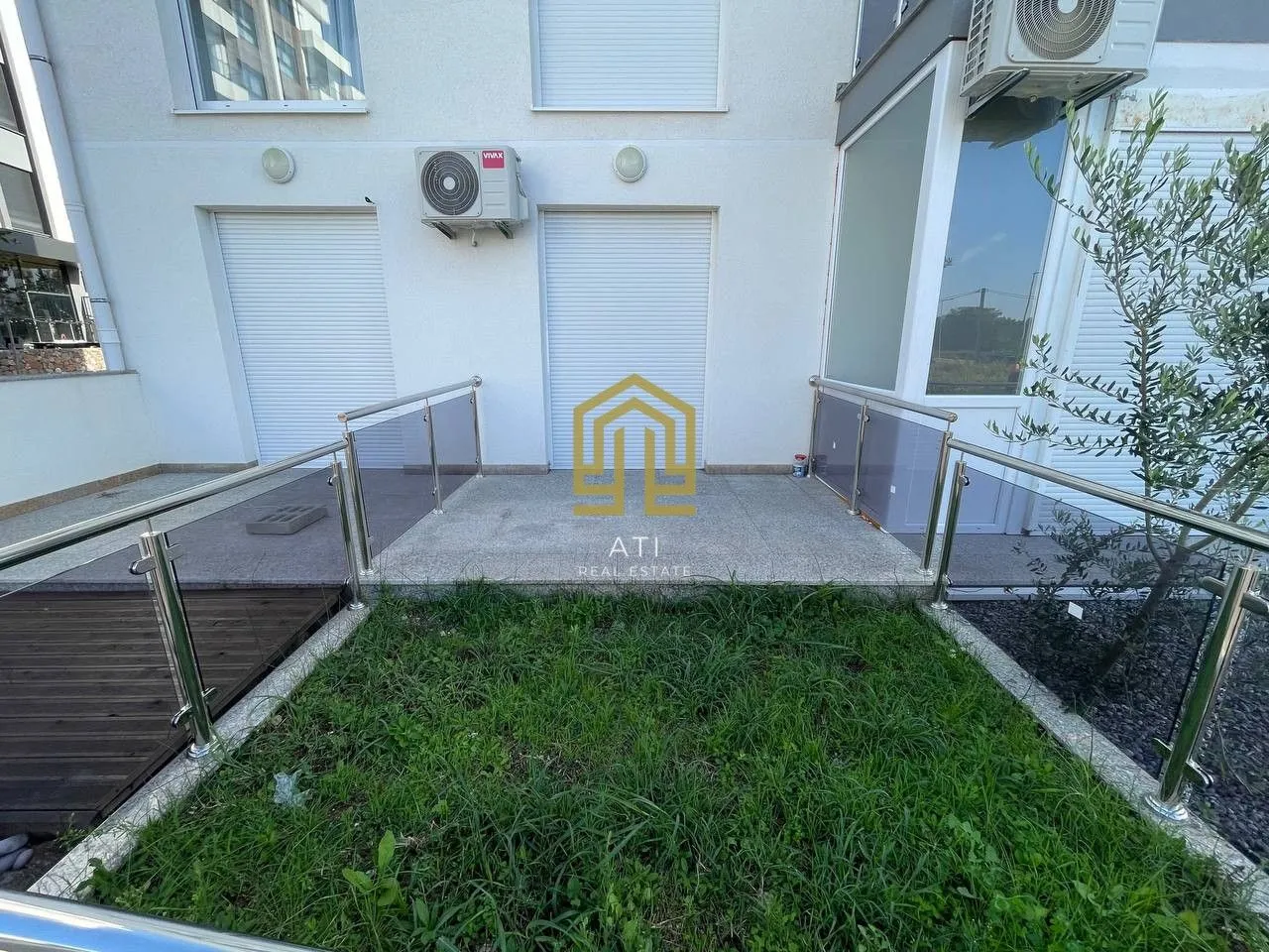 Dvorište sa terasom ispred ulaza u zgradu.
