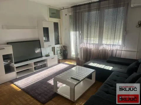 Dnevna soba sa garniturom, televizorom i izlazom na terasu. - image 2