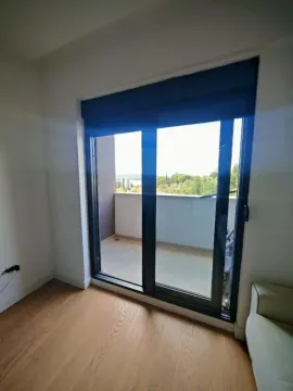 Pogled iz sobe kroz balkonska vrata prema spoljašnjem prostoru i okolini. - image 10