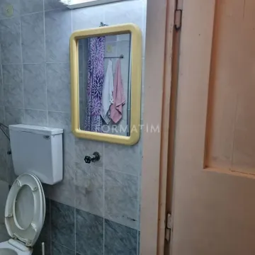 Small bathroom with tiled walls, toilet bowl, and mirror. - image 6