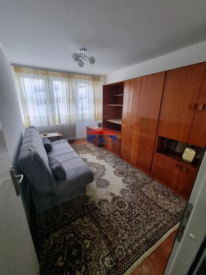 Small bedroom with a pull-out sofa and a large wooden wardrobe.