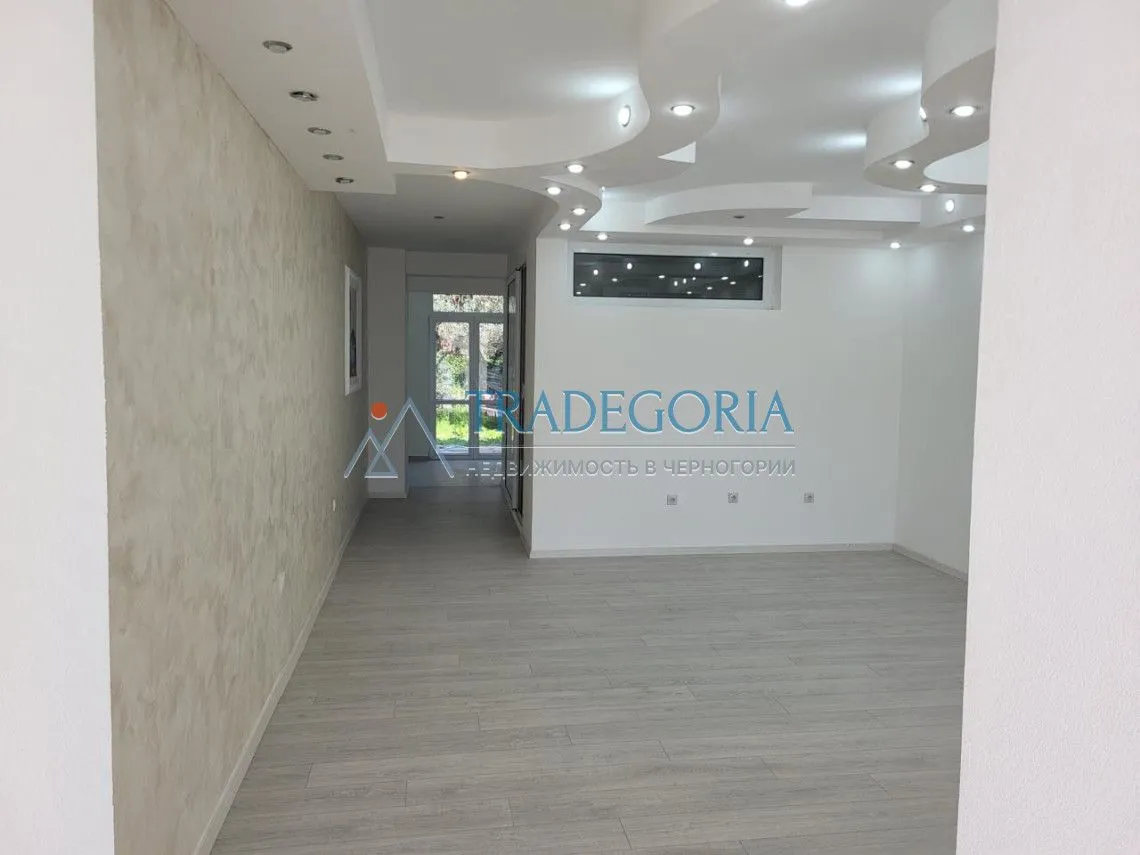 Prazna dnevna soba sa spuštenim plafonom i ugrađenom rasvjetom.