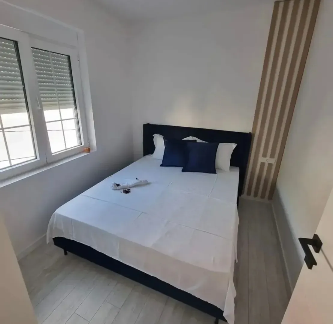 Furnished bedroom with a double bed and a window.
