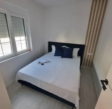 Furnished bedroom with a double bed and a window. - image 5