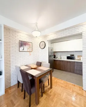 Dining area connected to the kitchen with a wooden table and chairs. - image 10