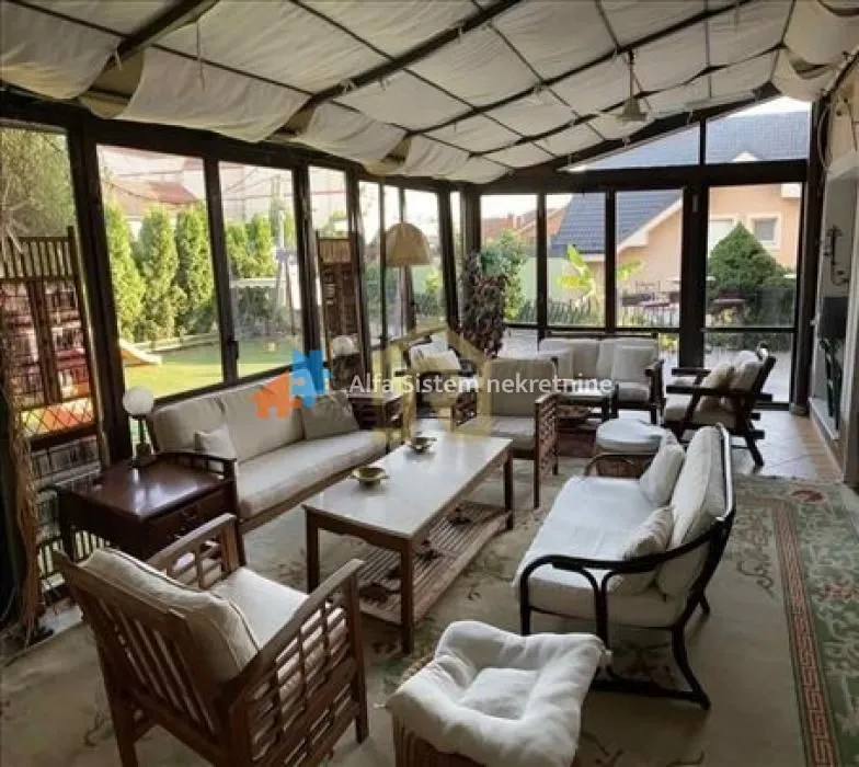 Enclosed terrace with seating set and view of the yard.