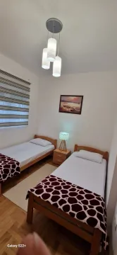 Bedroom with two single beds and a nightstand. - image 11