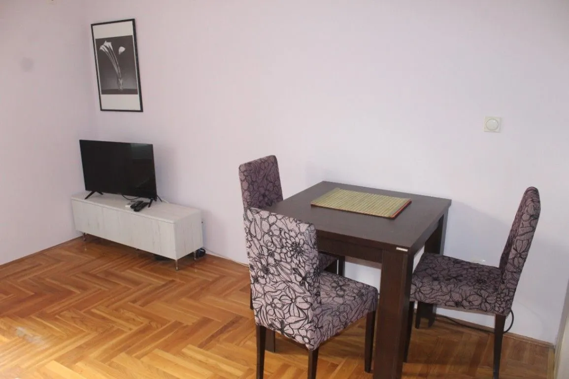 Living room with a dining table and a TV.