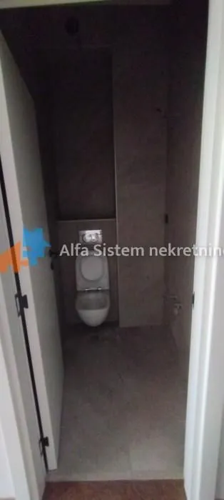 Pogled na kupatilo sa ugradnom wc šoljom i pločicama.