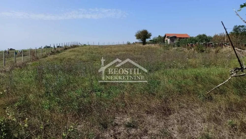 Pogled na prostrano zemljište sa travnatom površinom i ogradom.