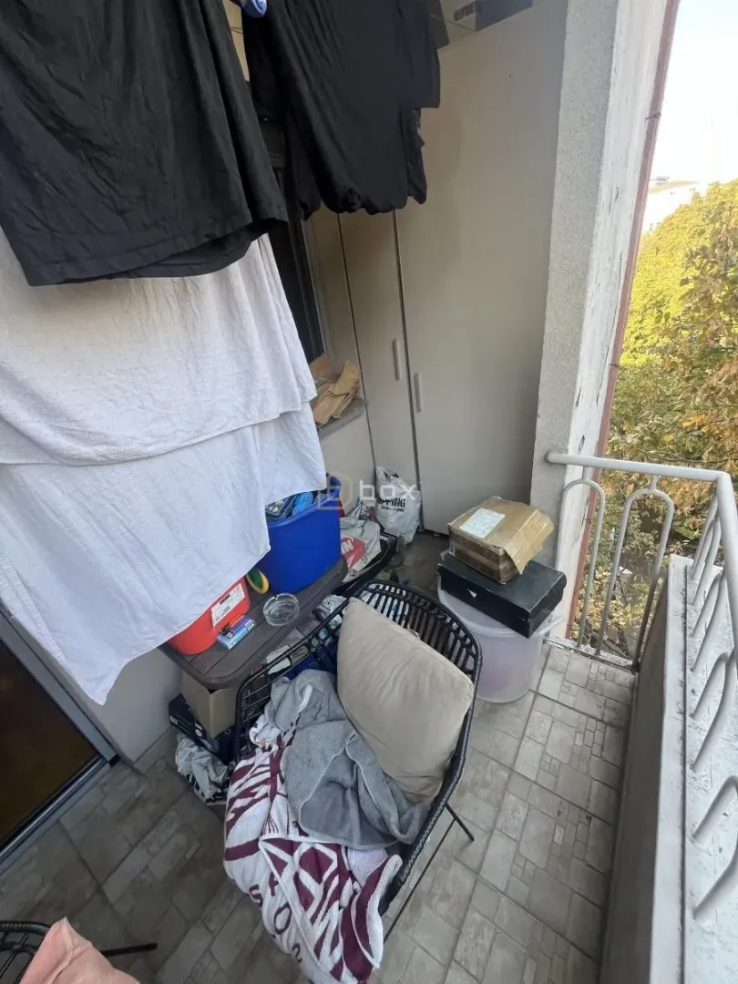 Manji balkon sa okačenim vešom i skladištenim stvarima.