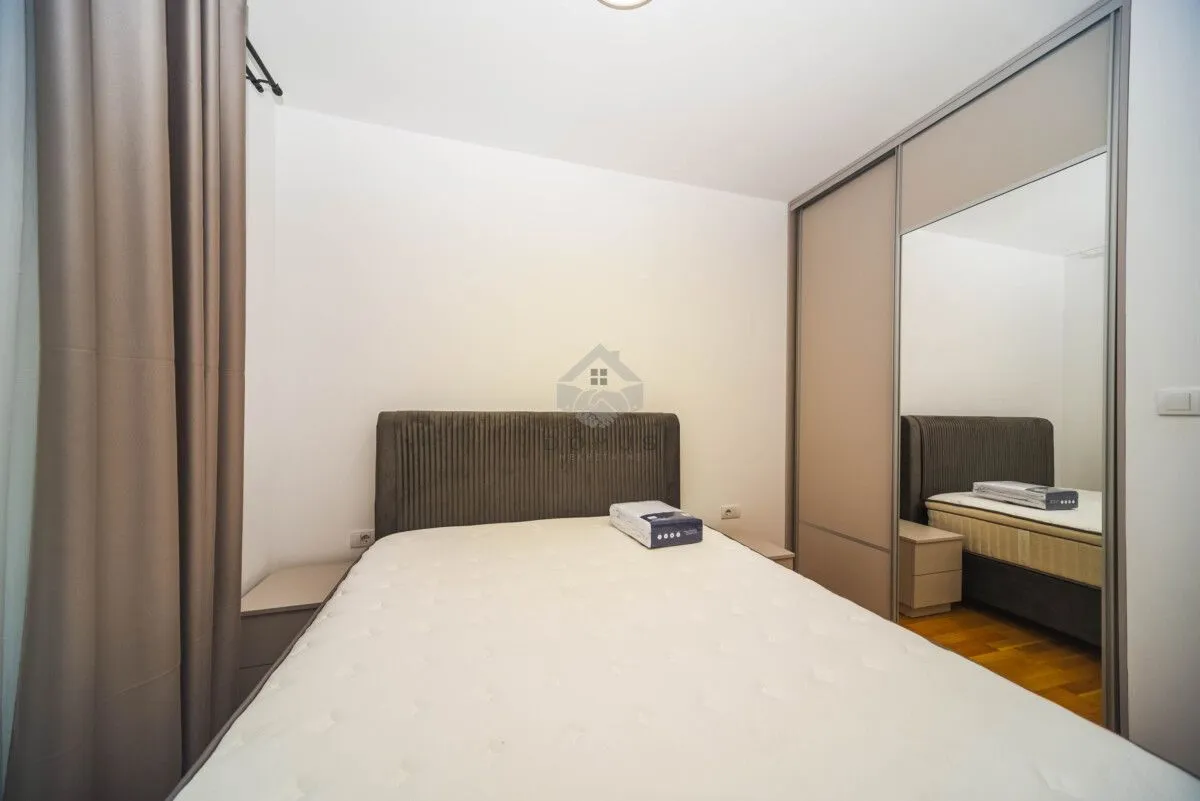 Furnished bedroom with a double bed and built-in wardrobe.