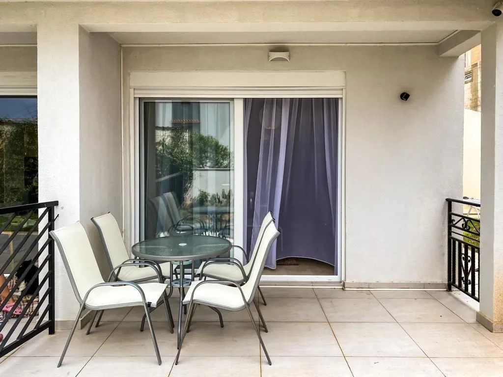 Covered terrace with a table, chairs, and access to the interior.