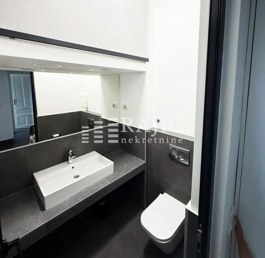 Modernly equipped bathroom with a washbasin and toilet.