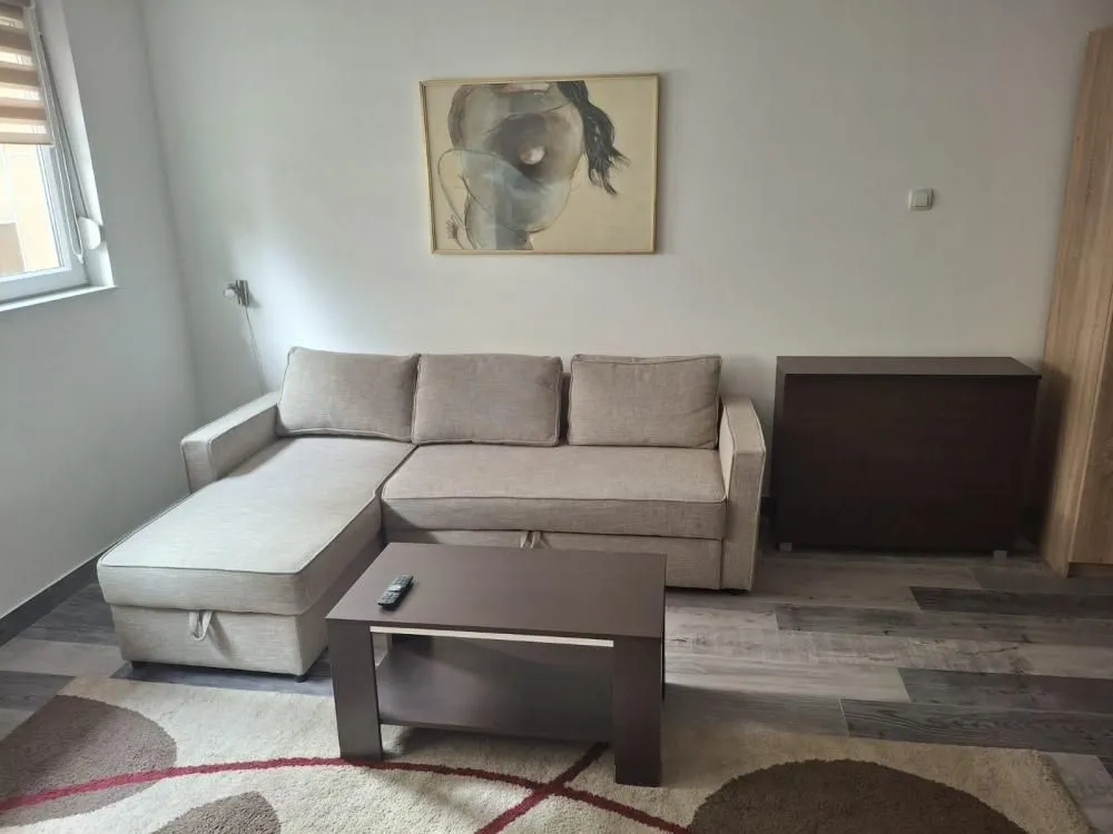 Living room with a sofa set, coffee table, and an artwork on the wall.