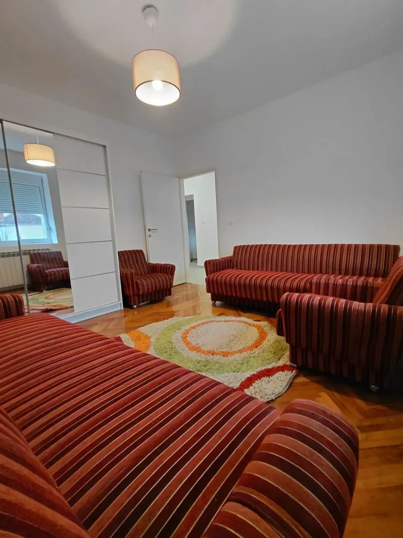 Living room with a sofa set and parquet flooring.
