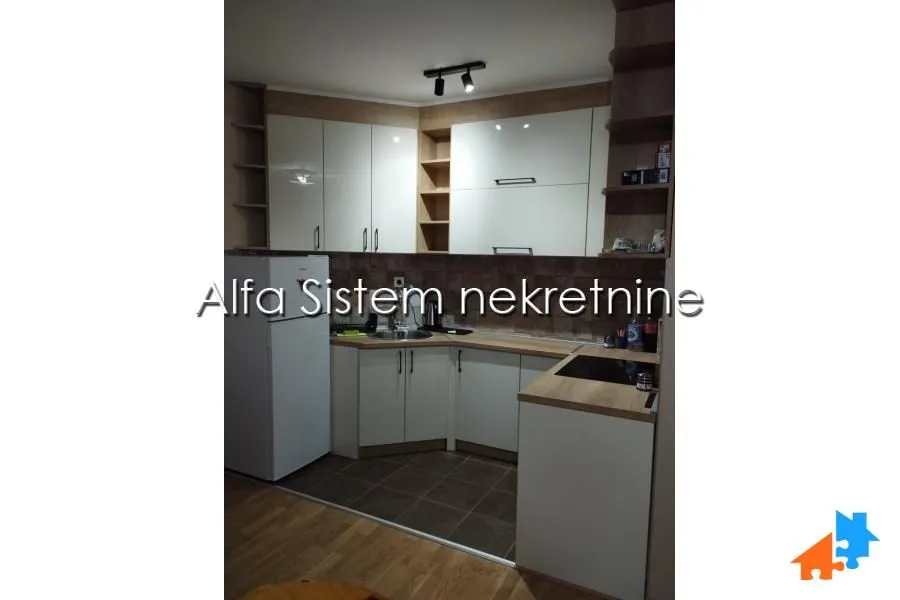 Compact corner kitchen with white cabinets and appliances.