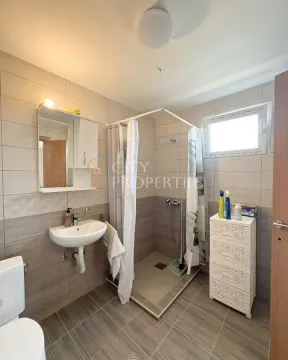 Bathroom equipped with a shower enclosure, sink, and tiles in neutral tones. - image 7