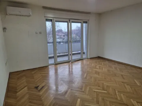 Empty room with parquet flooring and balcony access. - image 2