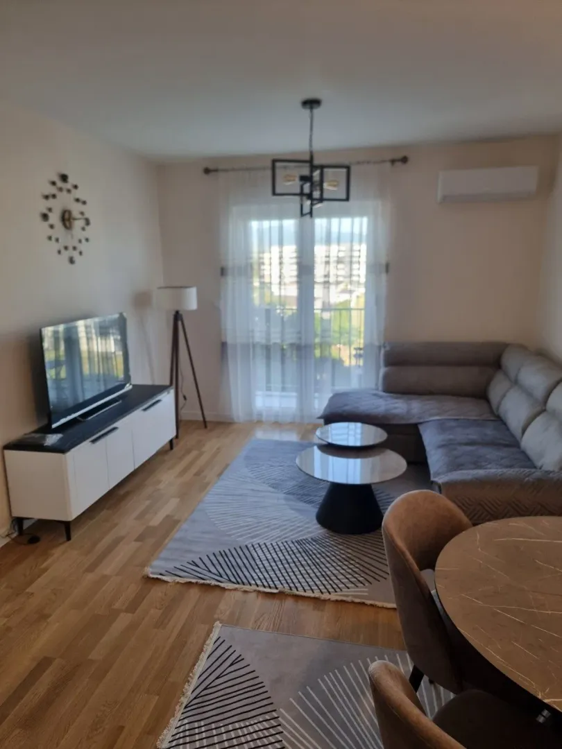 Living room with a sofa, TV, and dining table.
