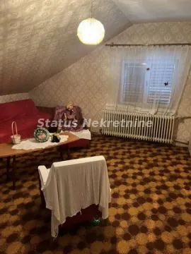 Dnevna soba sa krovnim kosinama, tepihom i garniturom za sedenje. - image 13