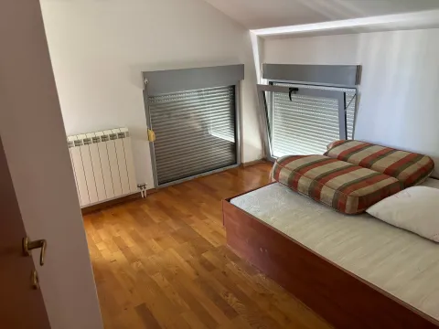 Potkrovna spavaća soba sa drvenim podom i dva krovna prozora. - image 2