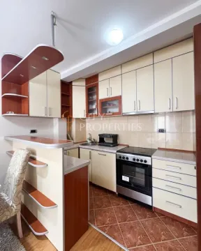 Kitchen equipped with wooden cabinetry, stove, and countertop. - image 2