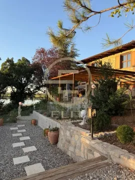 Pogled na dvorište i terasu kuće sa kamenim zidovima i zelenilom. - image 51