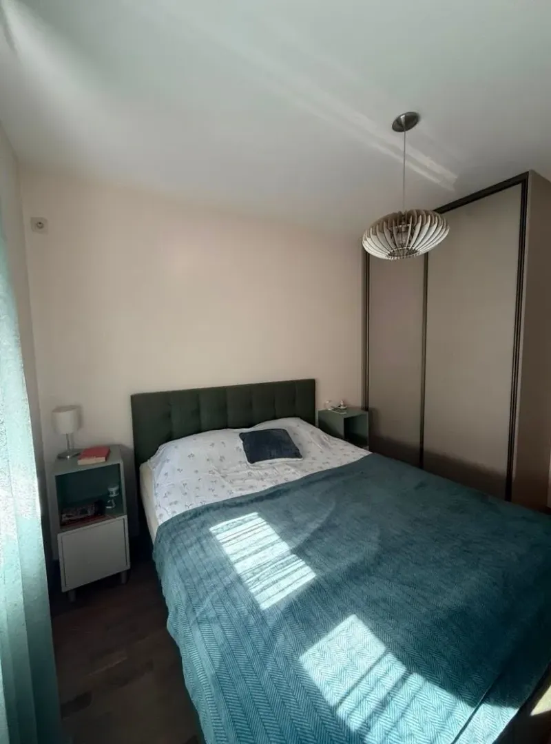 Furnished bedroom with a double bed, nightstands, and a wardrobe.