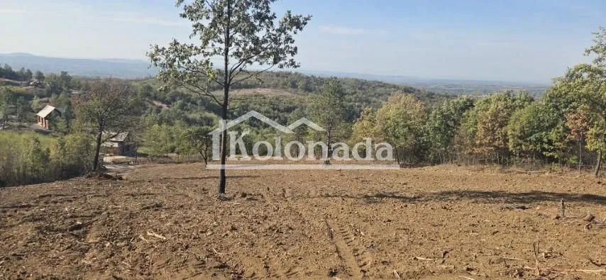 Pogled na zemljište i okolnu prirodu sa drvećem.