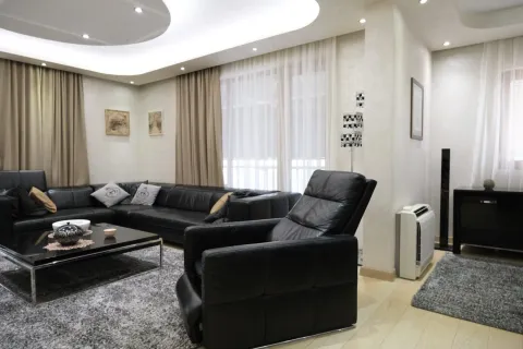 Spacious living room with a black leather sectional sofa and modern lighting. - image 2