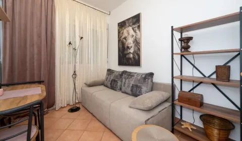 Living room with a sofa, shelving unit, and dining table. - image 9