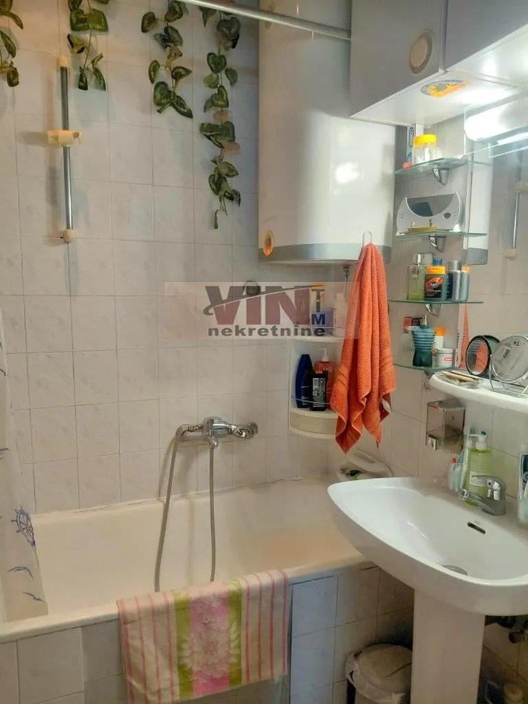 Small bathroom with a bathtub, washbasin, and water heater.
