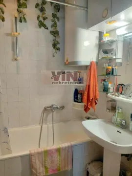 Small bathroom with a bathtub, washbasin, and water heater. - image 3