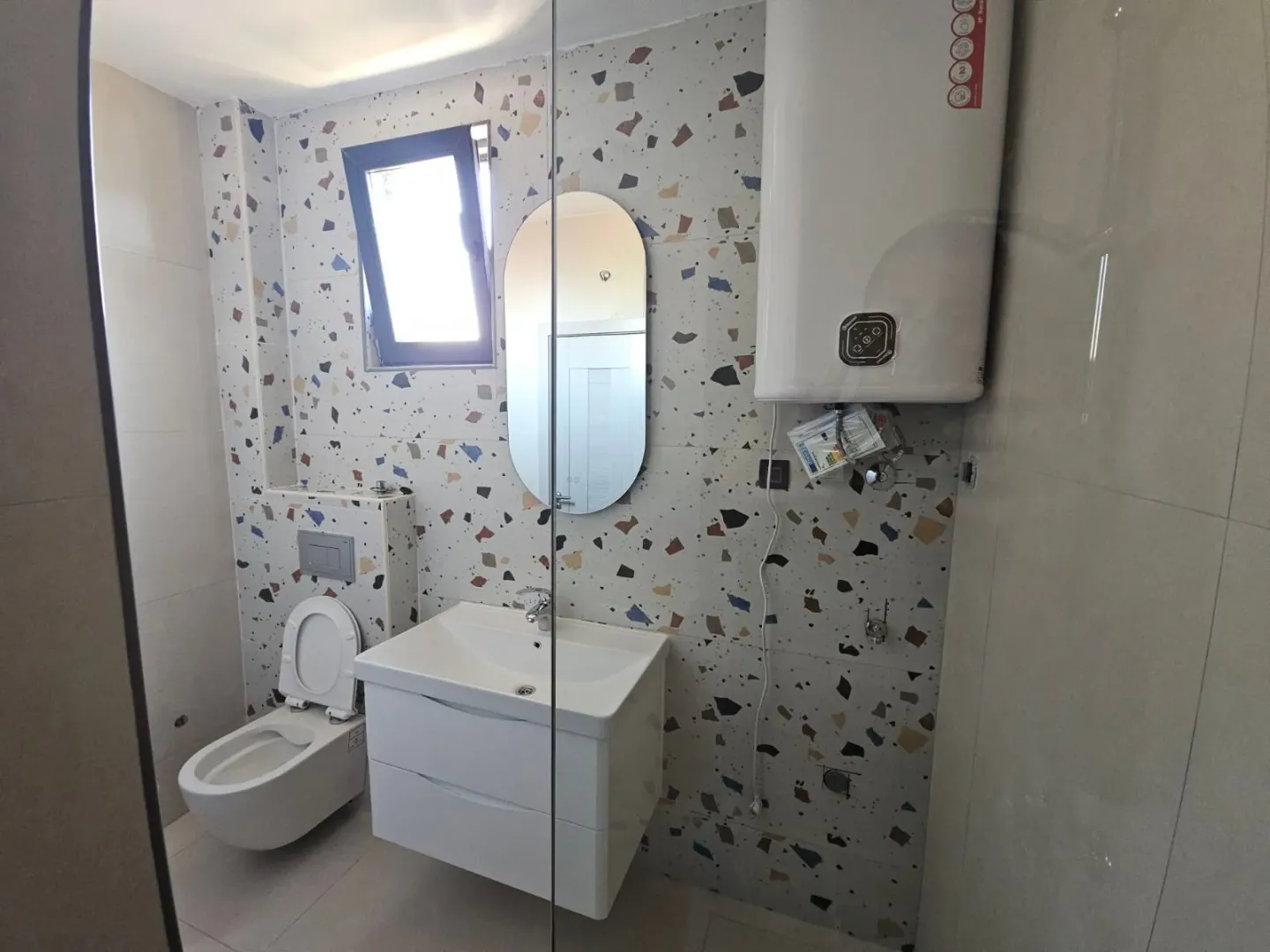 Moderne kupatilo sa umivaonikom, WC šoljom i bojlerom.