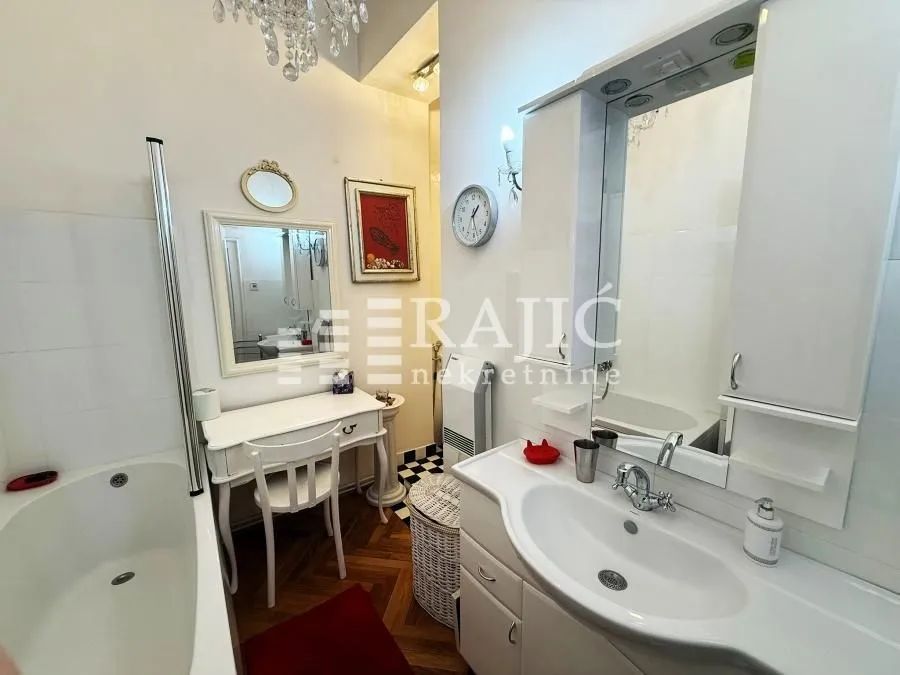 Spacious bathroom with a bathtub, washbasin, and white cabinetry.