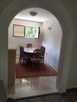 Dining area with a table and chairs, viewed through an arched doorway. - image 14