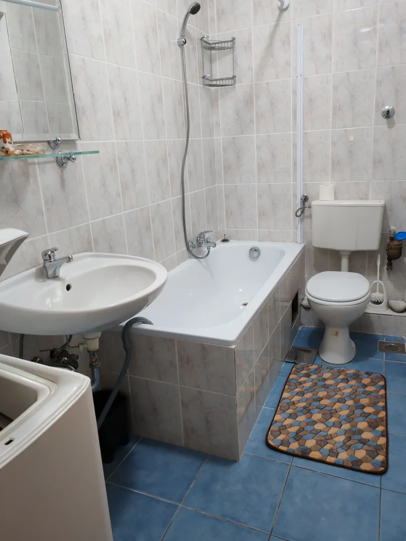 Manje opremljeno kupatilo sa kadom, umivaonikom i toaletom.