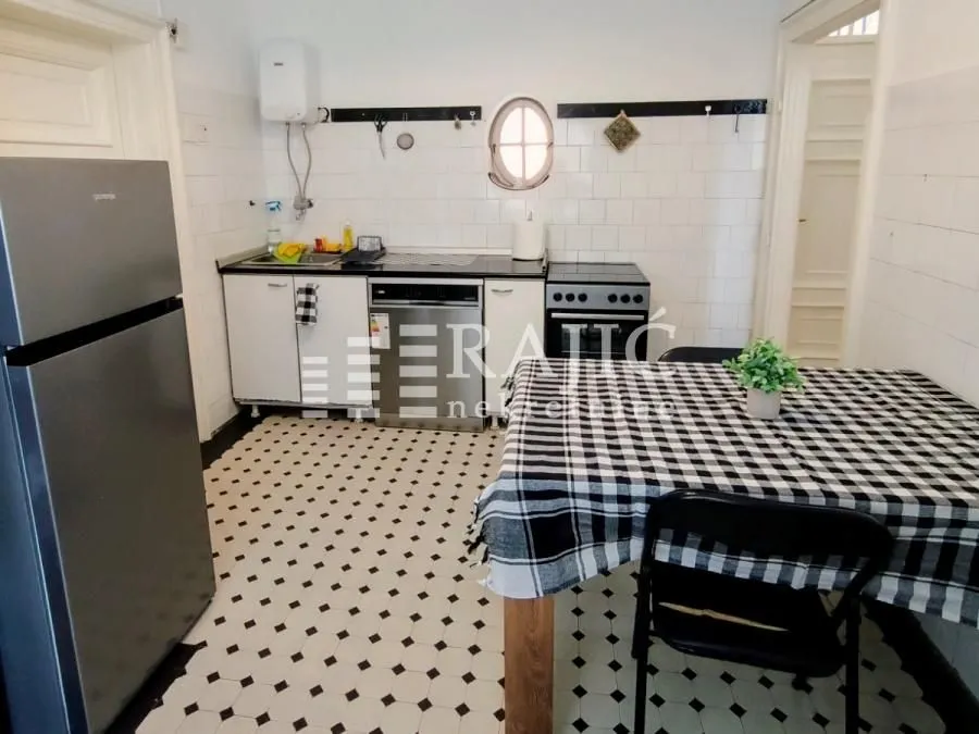 Small kitchen with a dining table and white cabinets.