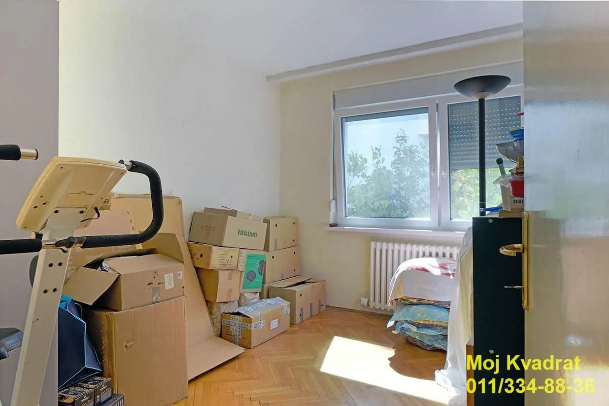 Prazna soba sa kartonskim kutijama i prozorom.