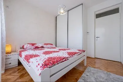 Bright bedroom with a double bed, wardrobe, and parquet flooring. - image 5