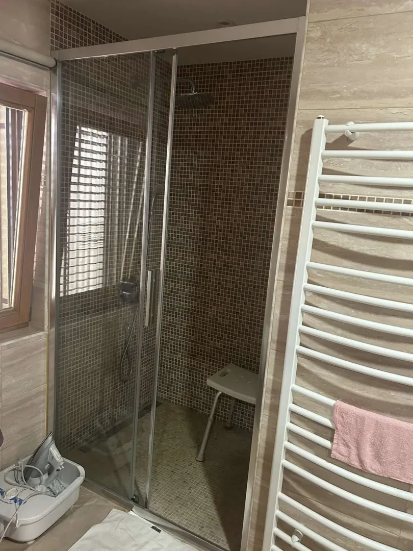 Bathroom featuring a glass shower cabin and a wall-mounted towel radiator.