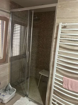 Bathroom featuring a glass shower cabin and a wall-mounted towel radiator. - image 23