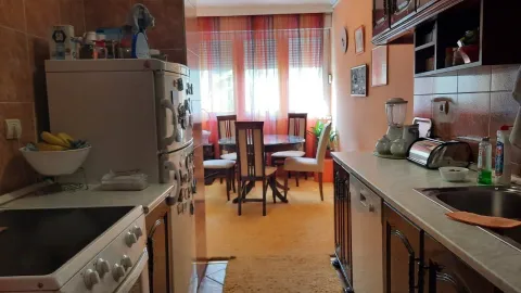 A kitchen with cabinets and a dining table in the background. - image 10