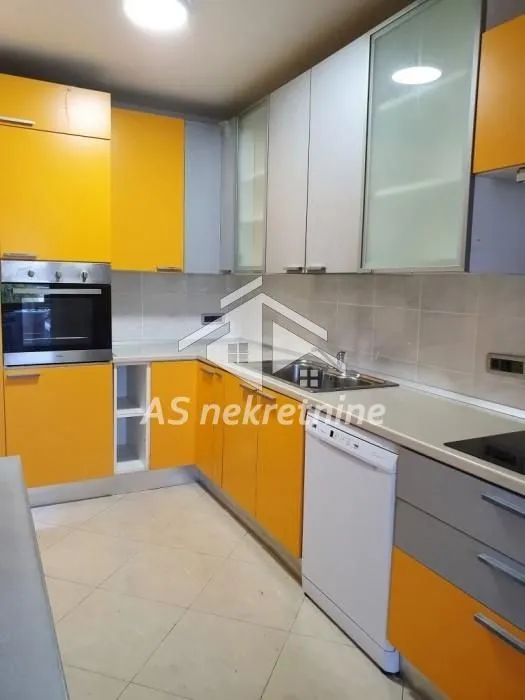 Kitchen equipped with yellow and white cabinetry, featuring a built-in oven and dishwasher.